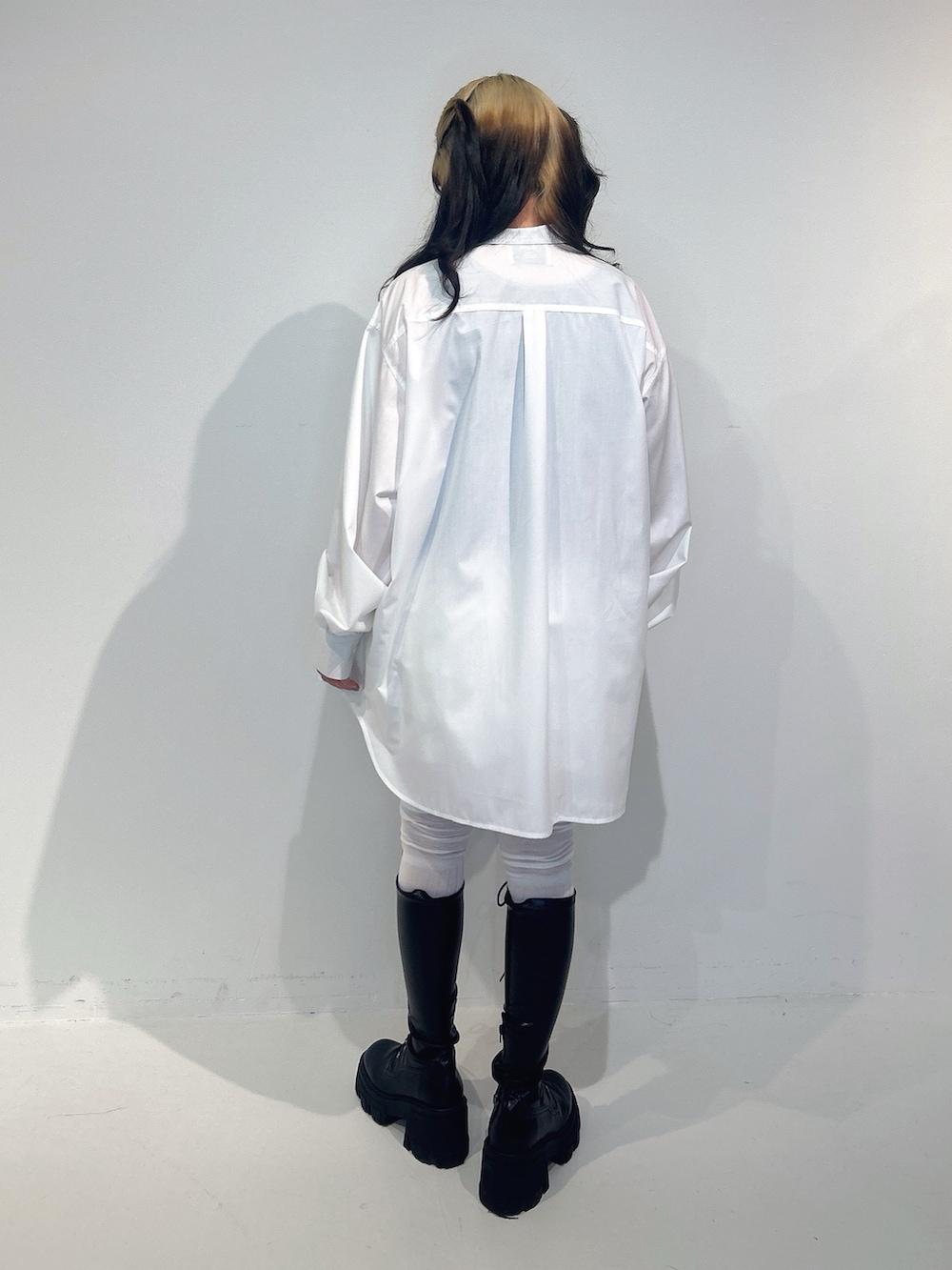 ホワイト系のシャツ/ブラウス、ホワイト系のスカート、ブラック系のブーツを着用したレディースの冬コーディネートの3枚目の写真