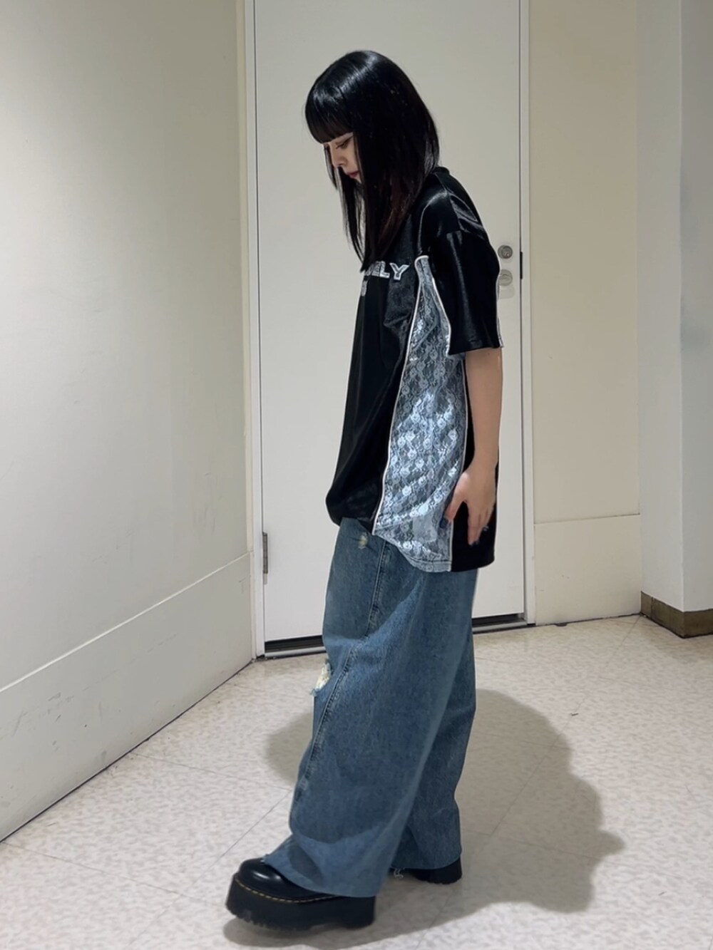 ブラック系のTシャツ/カットソー、ブラック系のその他シューズ、ブルー系のデニムパンツを着用したレディースの春コーディネートの2枚目の写真