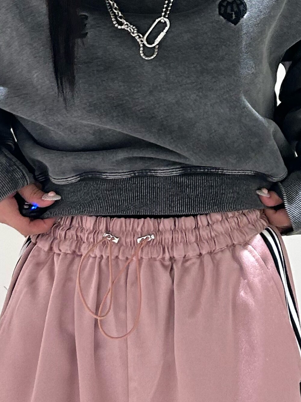 ピンク系のその他パンツ、ブラック系のスウェット、ブラック系のブーツを着用したレディースの冬コーディネートの5枚目の写真