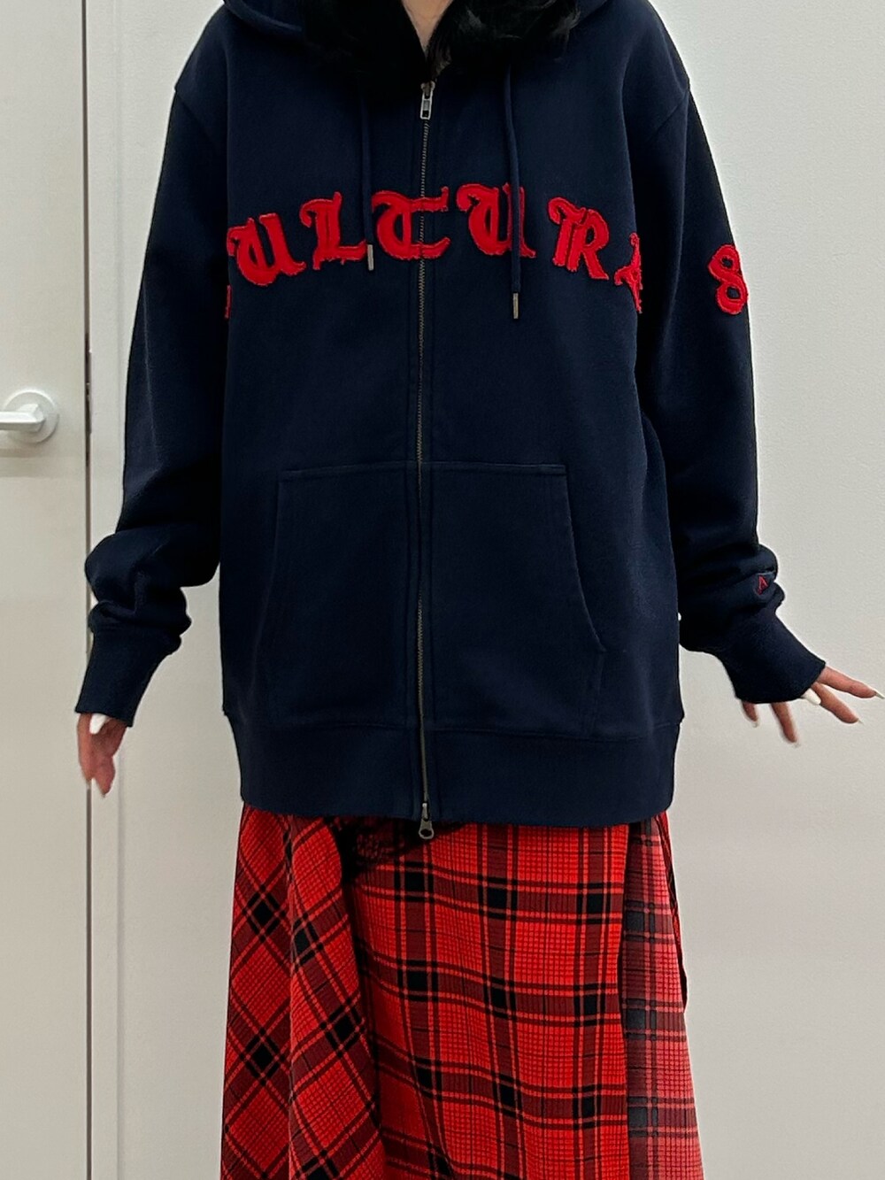ブルー系のパーカー、レッド系のスカート、ブラック系のローファーを着用したレディースの春コーディネートの4枚目の写真