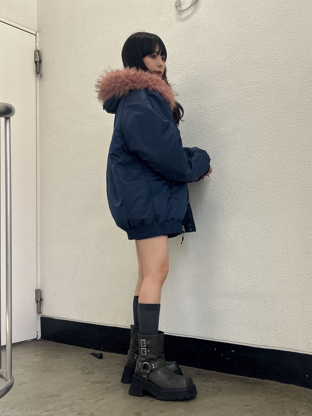 ブルー系のブルゾン、ブラック系のブーツを着用したレディースの秋コーディネートの2枚目の写真