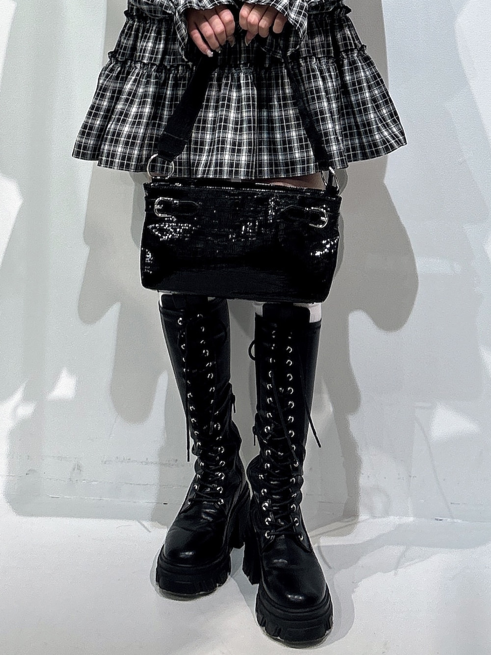 ブラック系のワンピース、ブラック系のハンドバッグ、ブラック系のブーツを着用したレディースの冬コーディネートの5枚目の写真