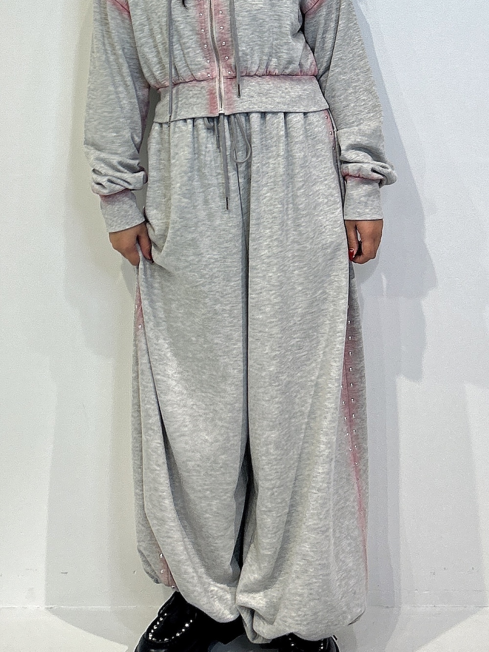 グレー系のパーカー、グレー系のスウェットパンツ、ブラック系のローファーを着用したレディースの冬コーディネートの5枚目の写真