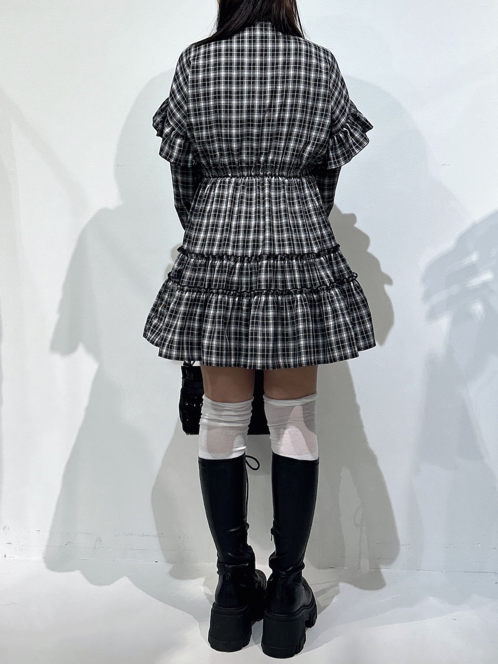 ブラック系のワンピース、ブラック系のハンドバッグ、ブラック系のブーツを着用したレディースの冬コーディネートの3枚目の写真