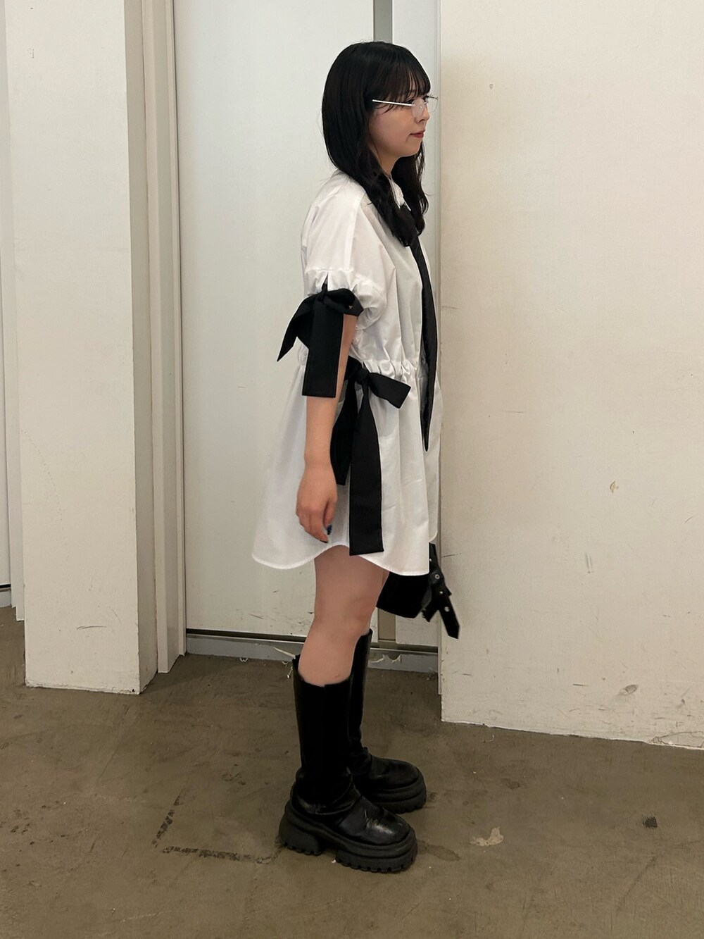 ホワイト系のシャツ/ブラウス、ブラック系のネクタイ、ブラック系のブーツを着用したレディースの春コーディネートの2枚目の写真