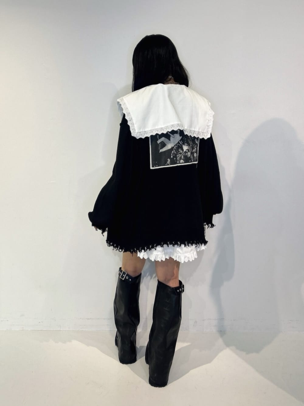 ブラック系のブーツ、ブラック系のカーディガン/ボレロ、ホワイト系のワンピースを着用したレディースの夏コーディネートの3枚目の写真