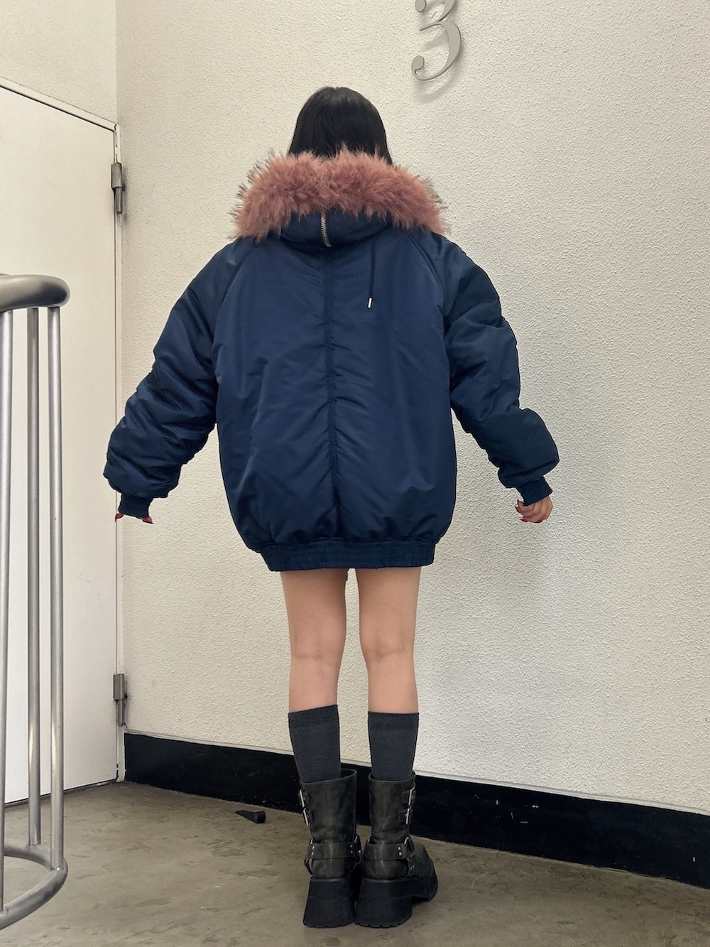 ブルー系のブルゾン、ブラック系のブーツを着用したレディースの秋コーディネートの3枚目の写真