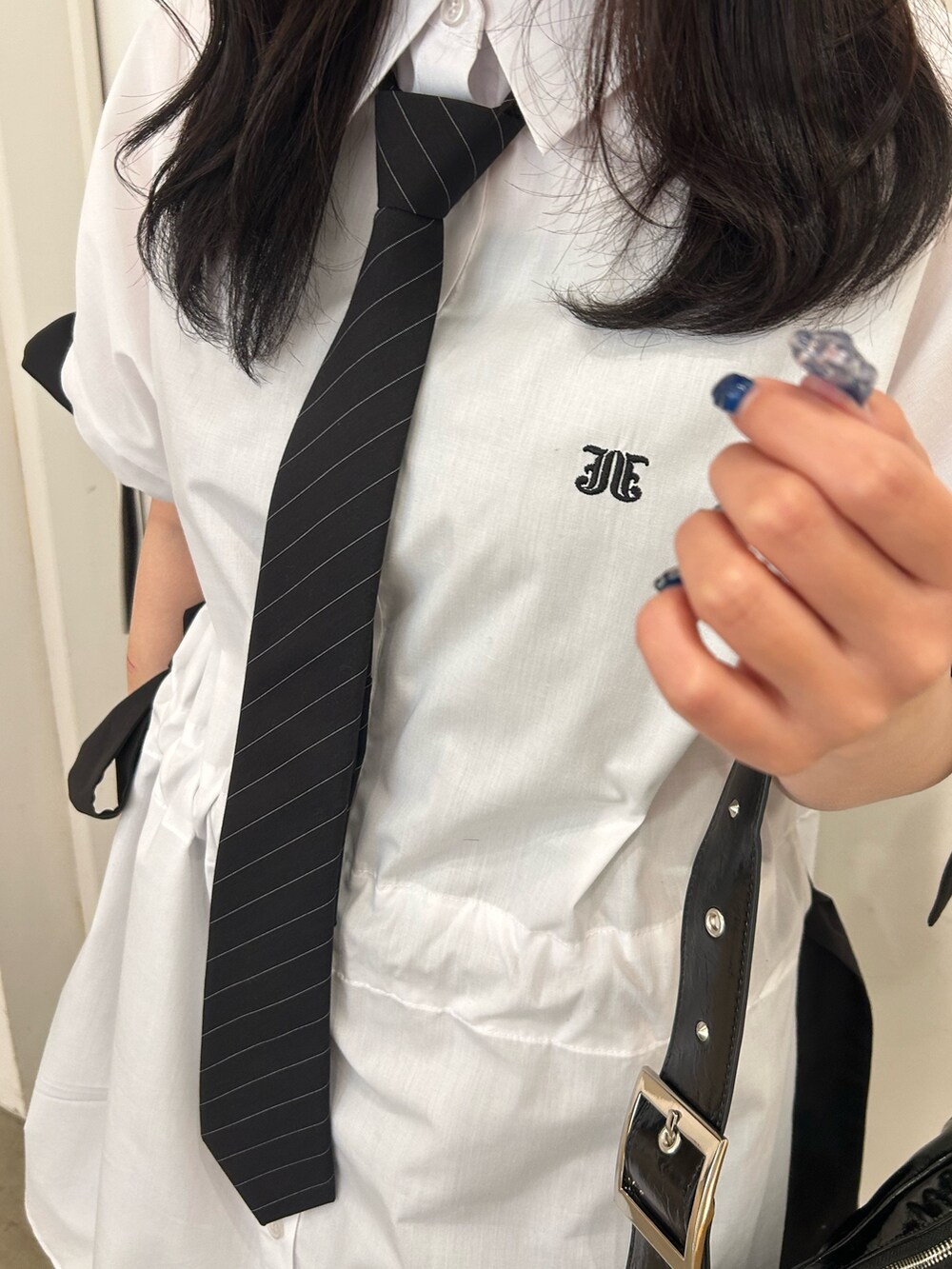 ホワイト系のシャツ/ブラウス、ブラック系のネクタイ、ブラック系のブーツを着用したレディースの春コーディネートの6枚目の写真