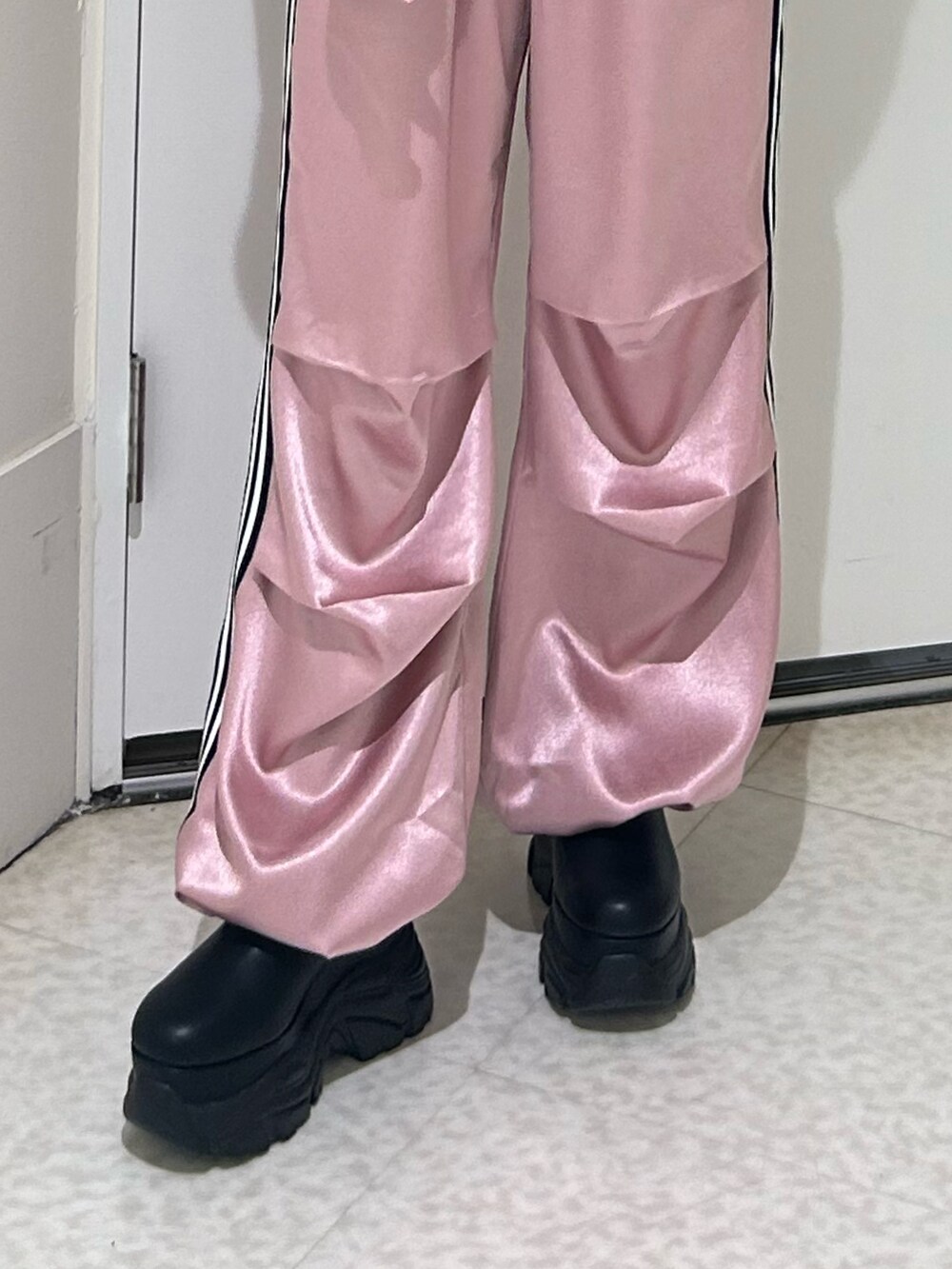 ピンク系のその他パンツ、ブラック系のスウェット、ブラック系のブーツを着用したレディースの冬コーディネートの6枚目の写真