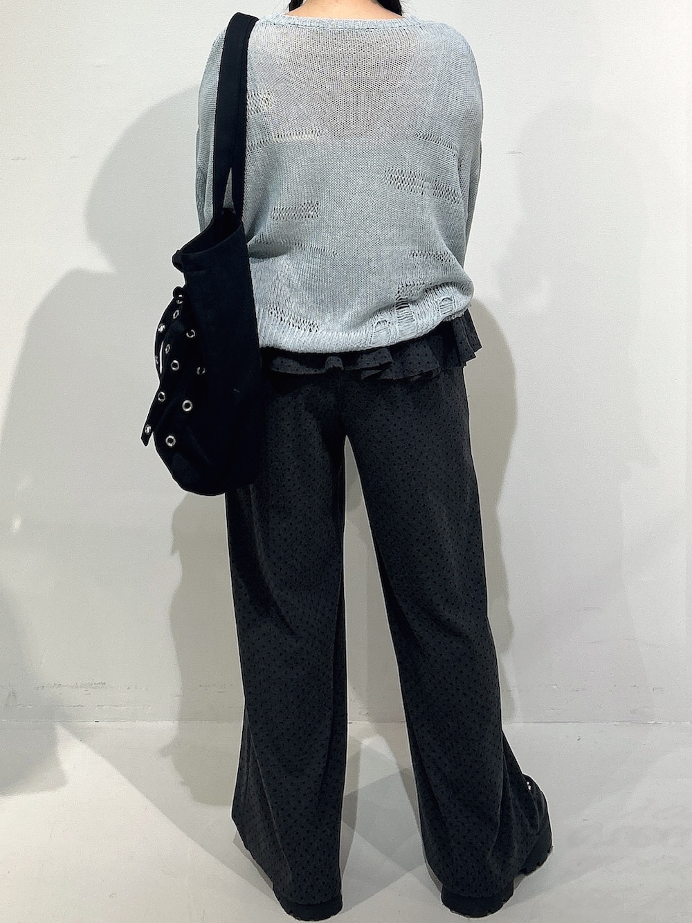 ブラック系のトートバッグ、ブルー系のニット/セーター、グレー系のスウェットパンツを着用したレディースの冬コーディネートの3枚目の写真