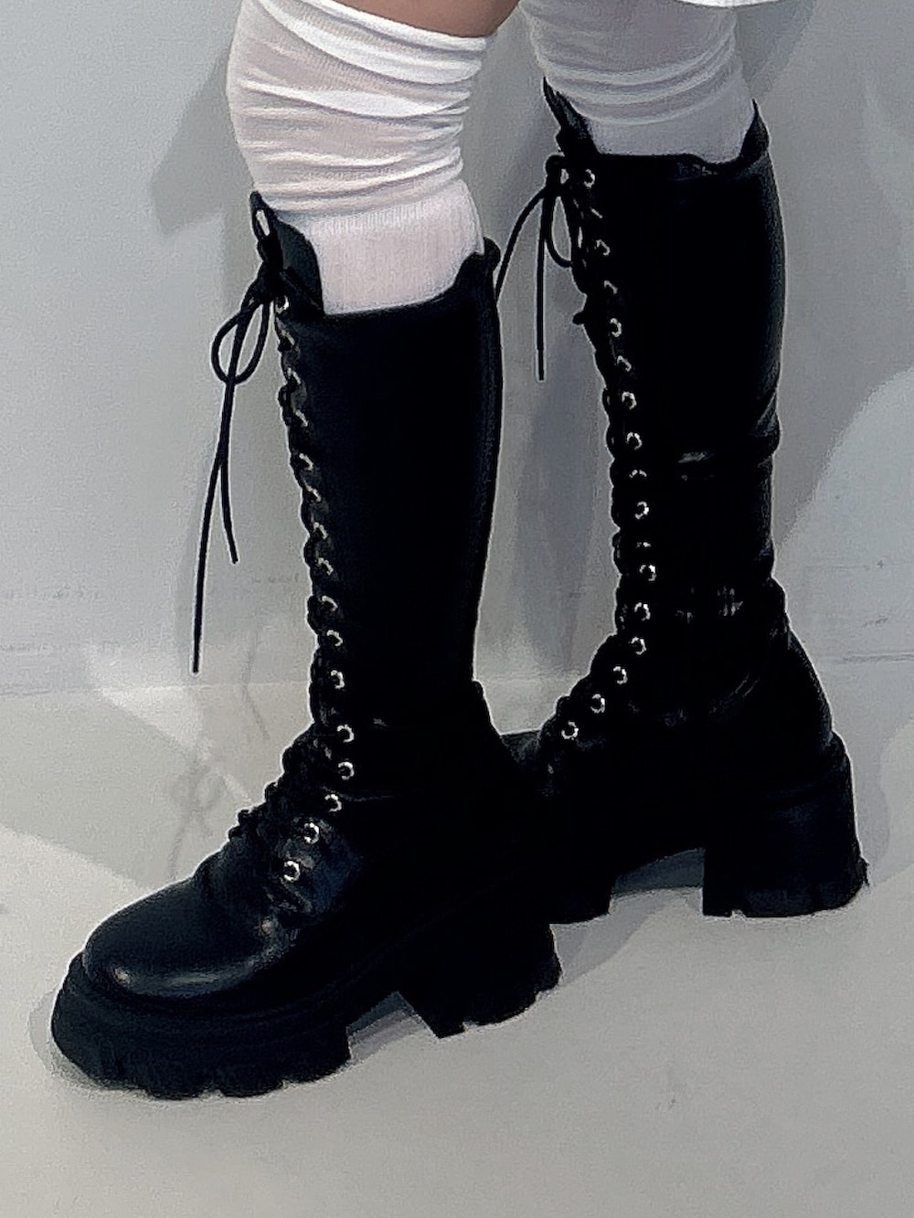 ホワイト系のシャツ/ブラウス、ホワイト系のスカート、ブラック系のブーツを着用したレディースの冬コーディネートの5枚目の写真