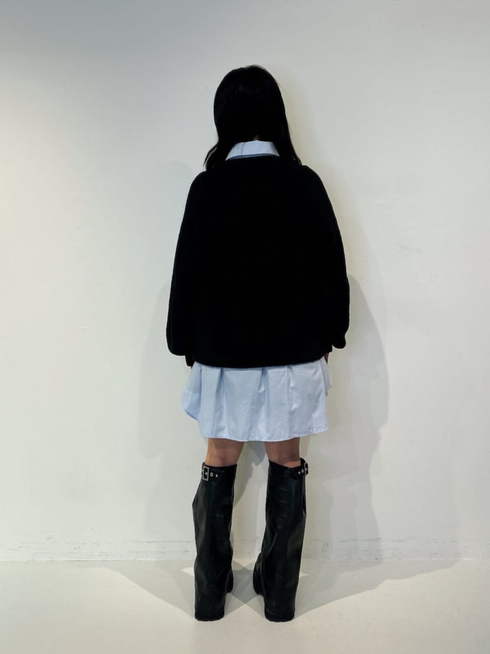 ブラック系のブーツ、ブラック系のニット/セーター、ブルー系のシャツ/ブラウスを着用したレディースの夏コーディネートの3枚目の写真