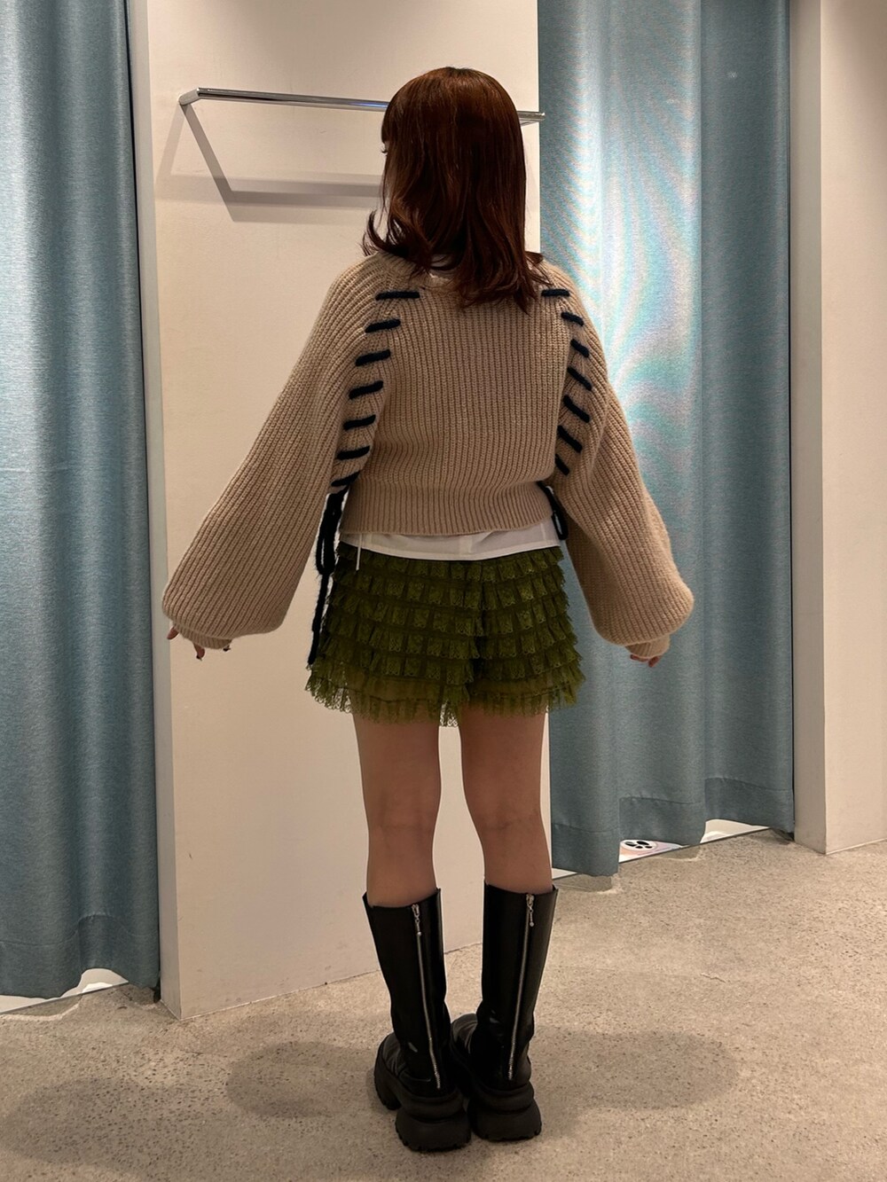 ホワイト系のカーディガン/ボレロ、グリーン系のその他パンツ、ブラック系のブーツを着用したレディースの冬コーディネートの3枚目の写真