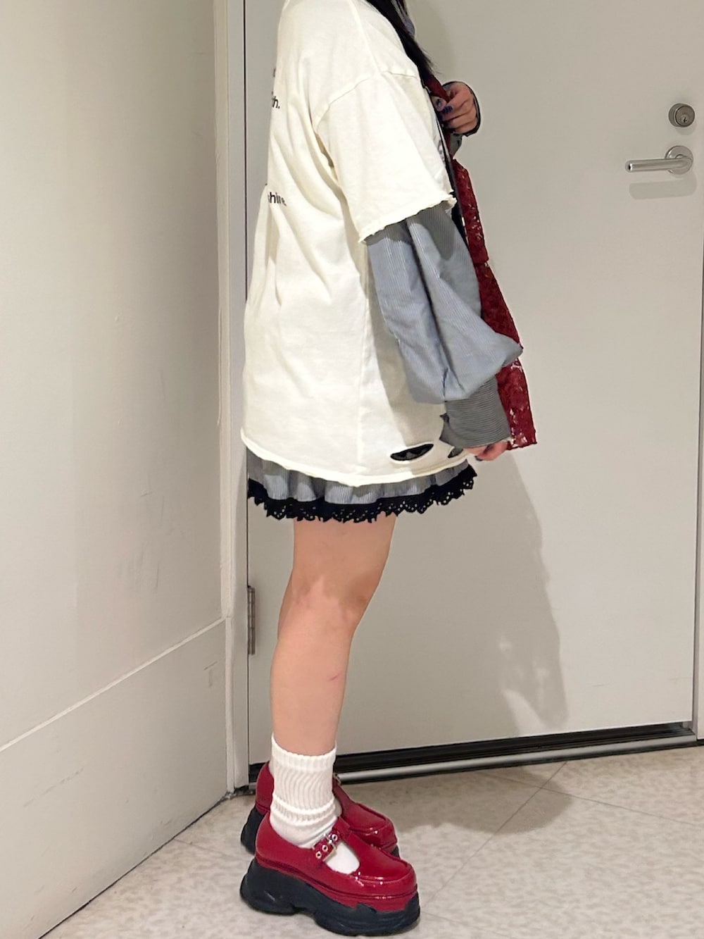 ホワイト系のTシャツ/カットソー、レッド系のスニーカー、レッド系のトートバッグを着用したレディースの春コーディネートの3枚目の写真