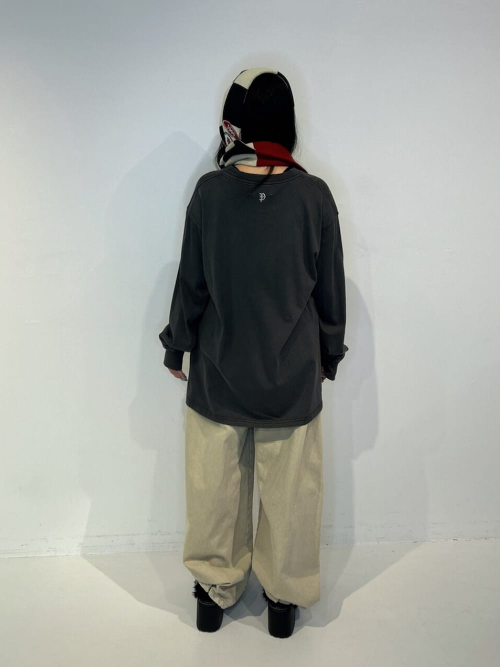 ブラック系のサンダル、ブラック系のTシャツ/カットソー、ベージュ系のデニムパンツを着用したレディースの秋コーディネートの3枚目の写真