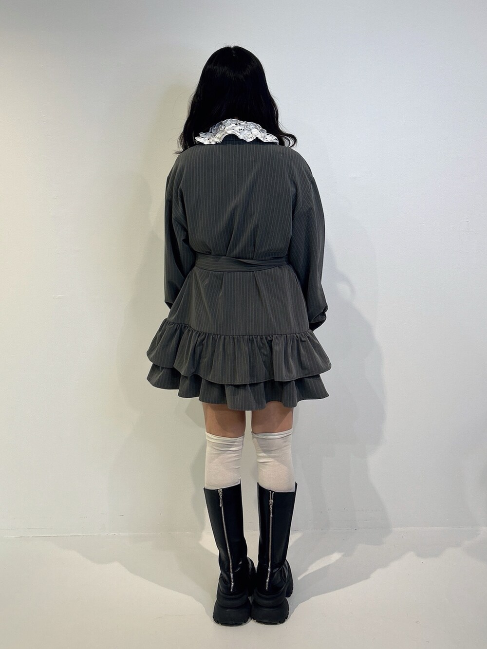 グレー系のワンピース、ブラック系のブーツを着用したレディースの秋コーディネートの3枚目の写真