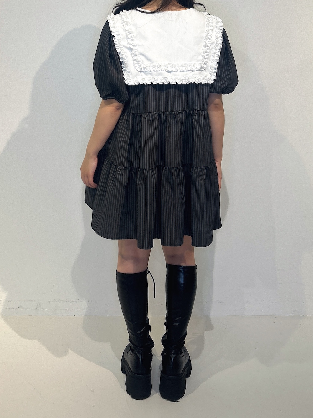 グレー系のワンピース、ブラック系のブーツを着用したレディースの冬コーディネートの3枚目の写真