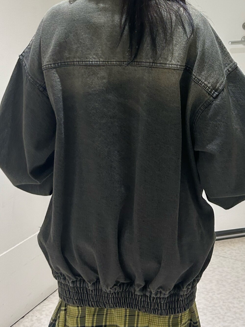 ブラック系のデニムジャケット、イエロー系のスカート、ブラック系のブーツを着用したレディースの春コーディネートの7枚目の写真