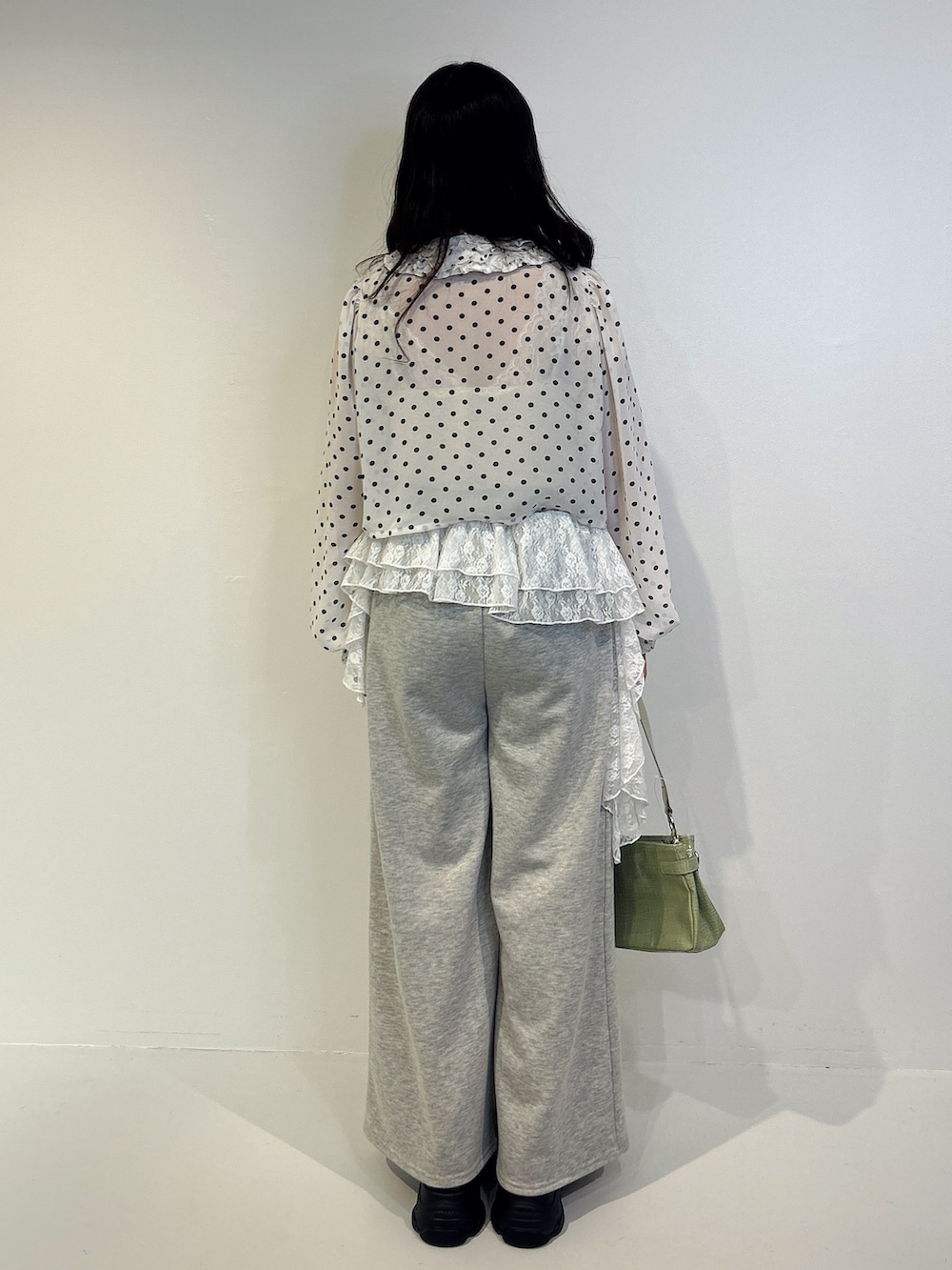 グレー系のスウェットパンツ、ブラック系のローファー、グリーン系のハンドバッグを着用したレディースの秋コーディネートの3枚目の写真