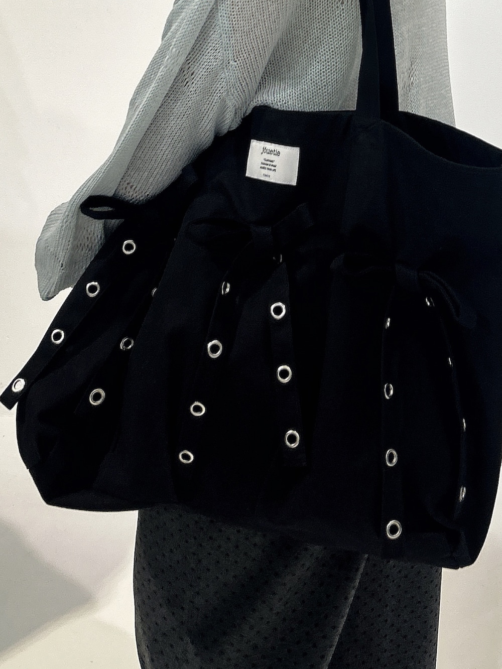 ブラック系のトートバッグ、ブルー系のニット/セーター、グレー系のスウェットパンツを着用したレディースの冬コーディネートの4枚目の写真