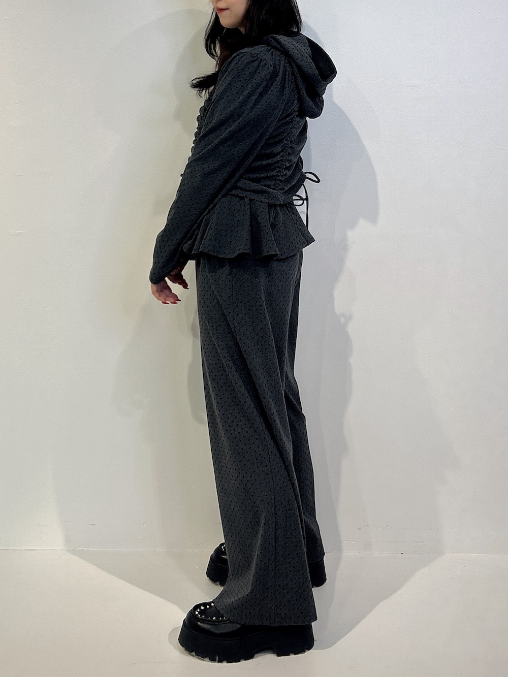 グレー系のスウェットパンツ、ブラック系のパーカー、ブラック系のローファーを着用したレディースの冬コーディネートの2枚目の写真