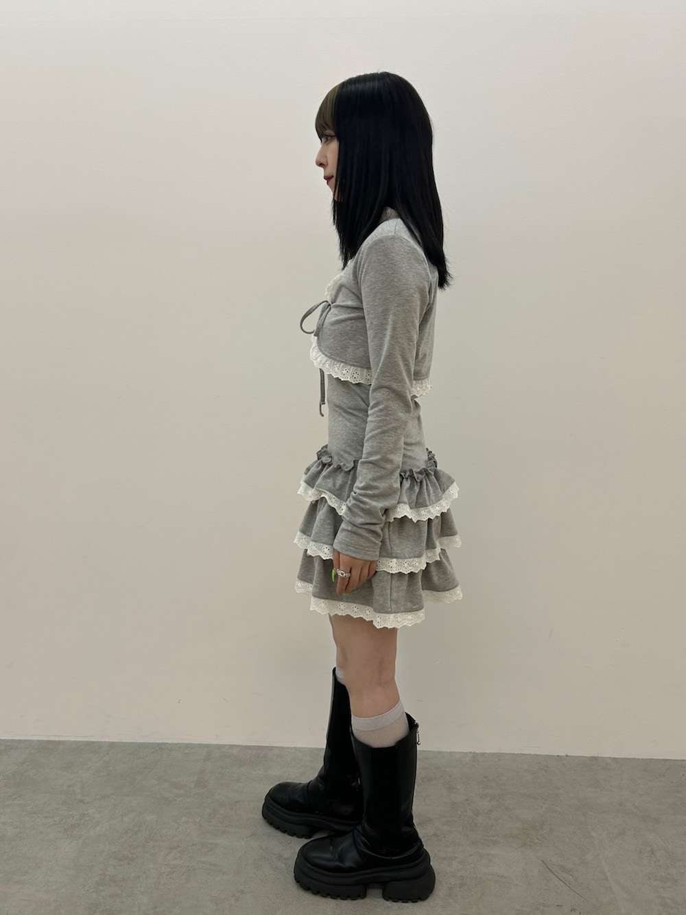 グレー系のワンピース、ブラック系のブーツ、ブルー系のチョーカーを着用したレディースの冬コーディネートの2枚目の写真