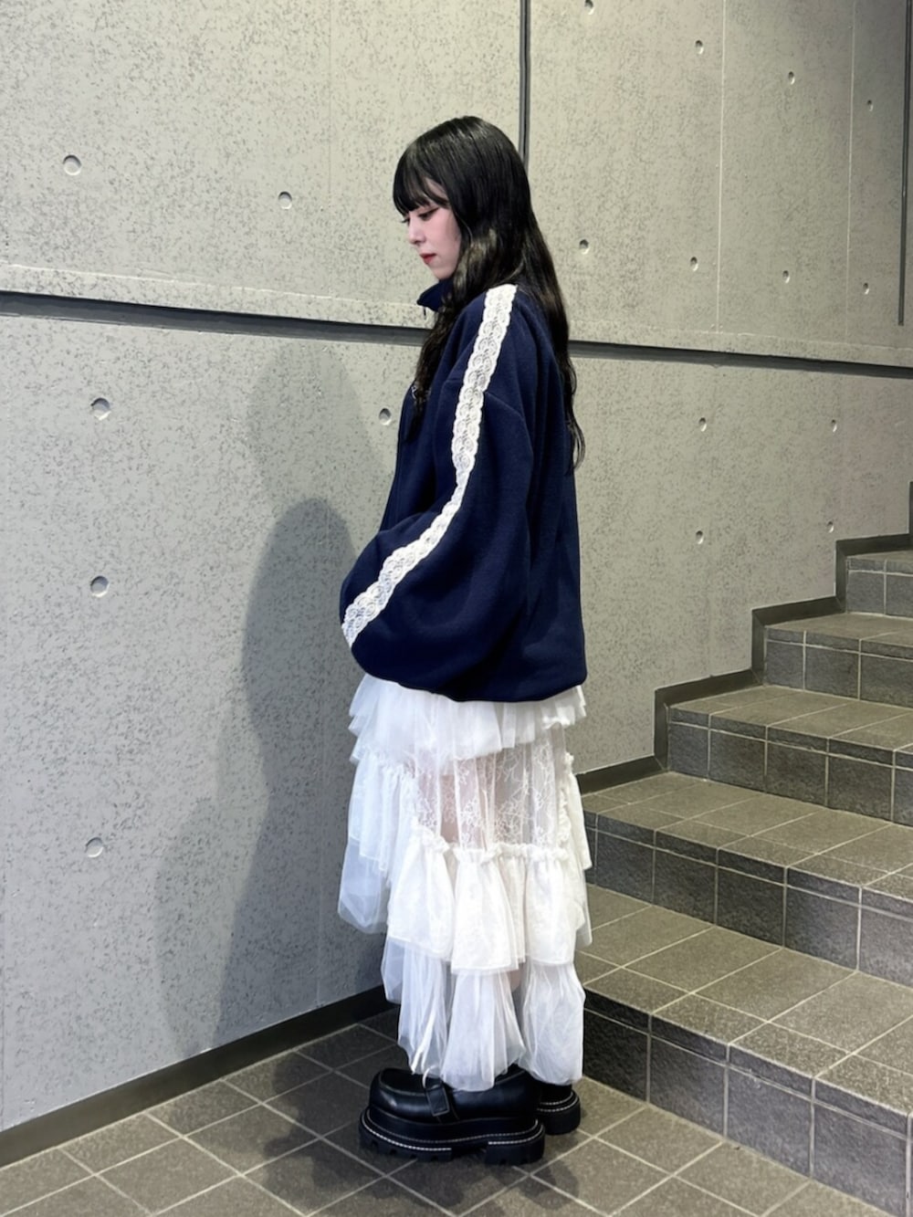 ホワイト系のスカート、ブラック系のローファー、ブルー系のTシャツ/カットソーを着用したレディースの秋コーディネートの2枚目の写真