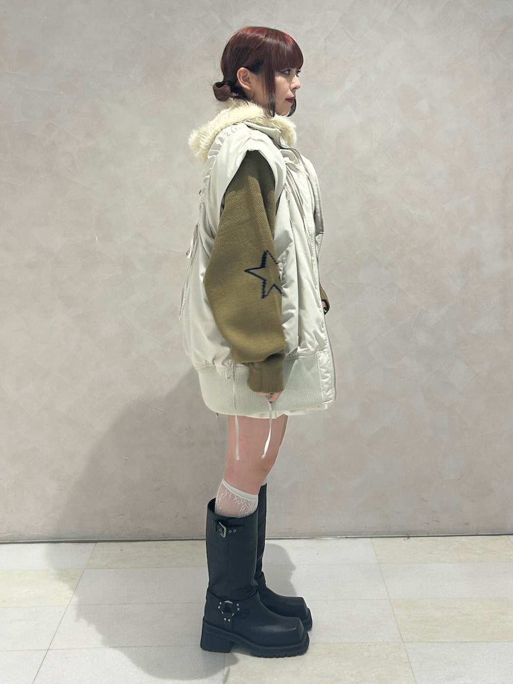 ブルー系のニット/セーター、ホワイト系のスカート、ホワイト系のダウンベストを着用したレディースの冬コーディネートの2枚目の写真