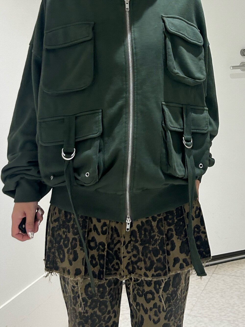 ブラウン系のその他パンツ、ブラック系のドレスシューズ、グリーン系のパーカーを着用したレディースの秋コーディネートの6枚目の写真