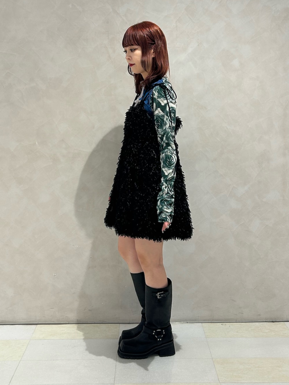 ブラック系のワンピース、ブラック系のブーツ、ブルー系のTシャツ/カットソーを着用したレディースの秋コーディネートの2枚目の写真