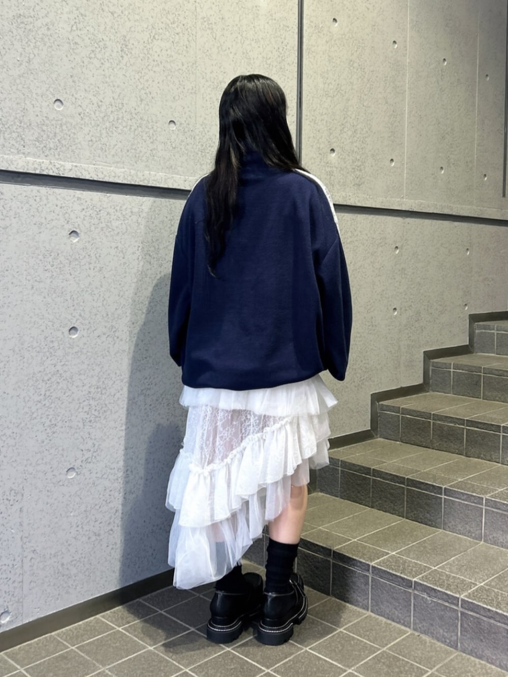 ホワイト系のスカート、ブラック系のローファー、ブルー系のTシャツ/カットソーを着用したレディースの秋コーディネートの3枚目の写真