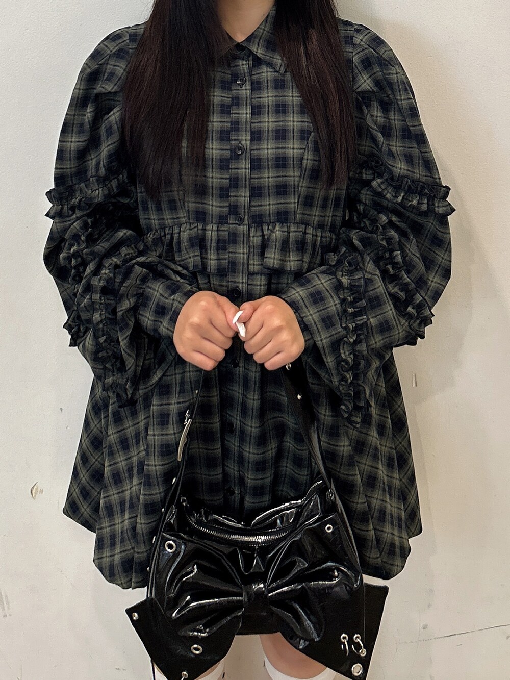 グリーン系のワンピース、ブラック系のショルダーバッグ、ブラック系のスニーカーを着用したレディースの秋コーディネートの4枚目の写真