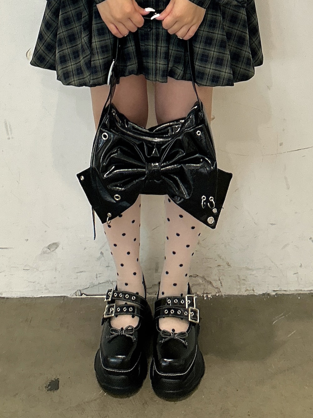 グリーン系のワンピース、ブラック系のショルダーバッグ、ブラック系のスニーカーを着用したレディースの秋コーディネートの5枚目の写真