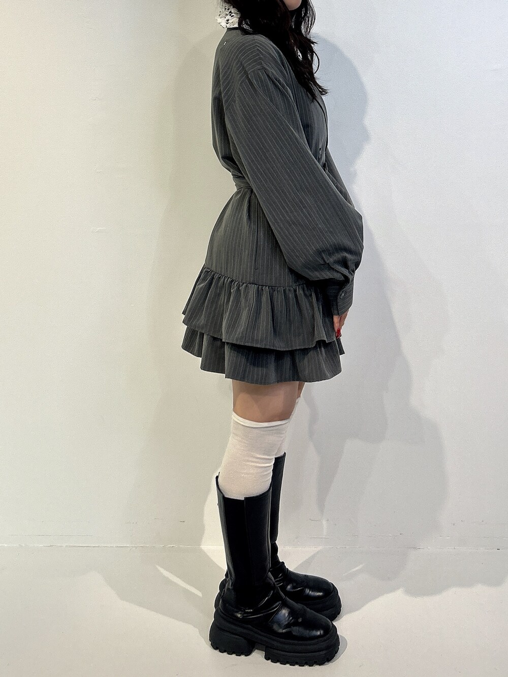 グレー系のワンピース、ブラック系のブーツを着用したレディースの秋コーディネートの2枚目の写真