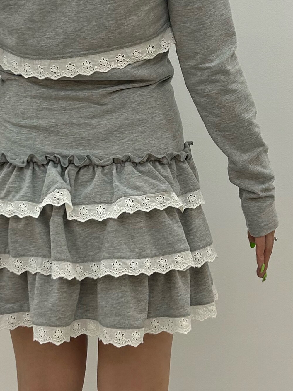 グレー系のワンピース、ブラック系のブーツ、ブルー系のチョーカーを着用したレディースの冬コーディネートの7枚目の写真