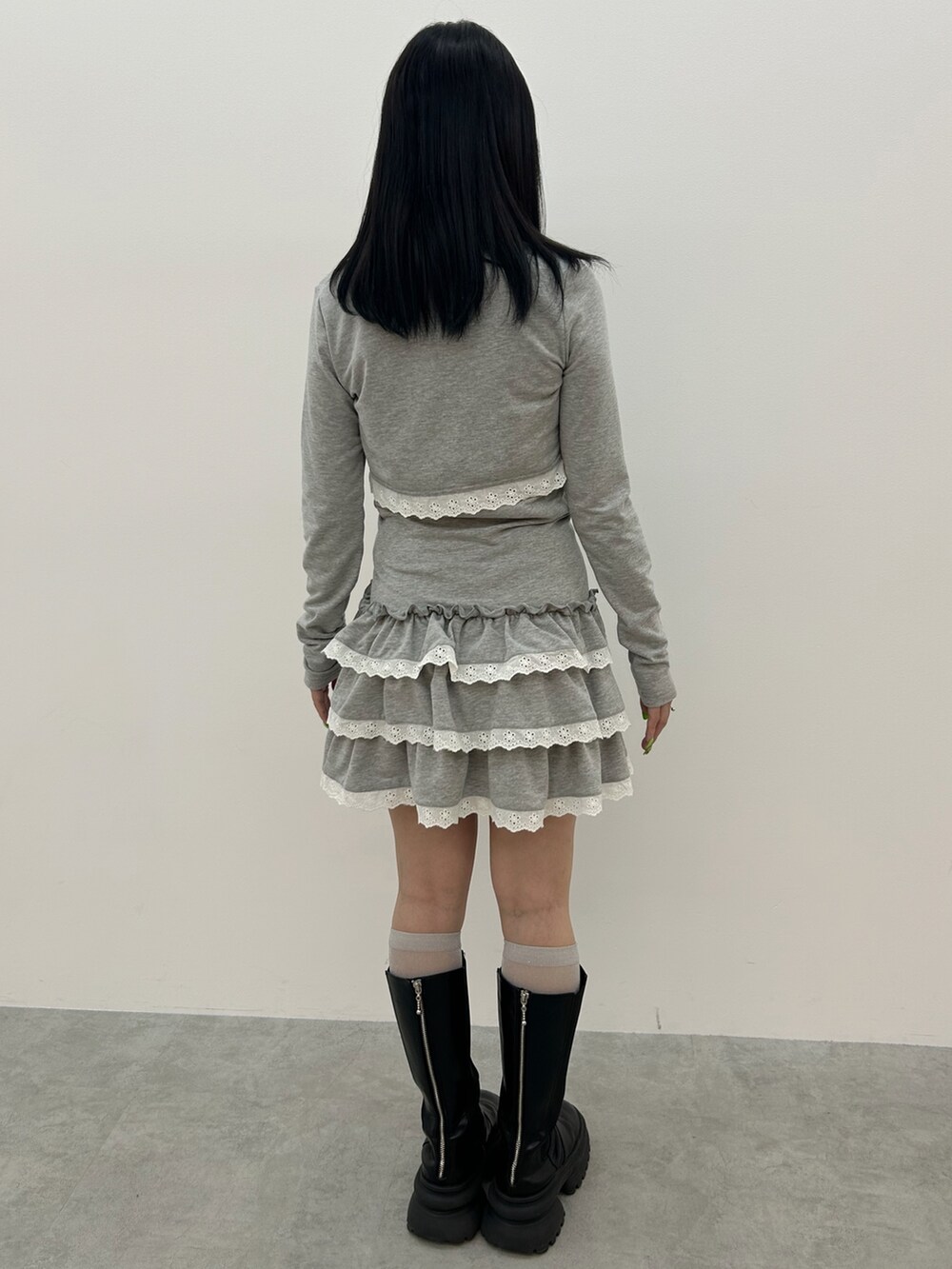 グレー系のワンピース、ブラック系のブーツ、ブルー系のチョーカーを着用したレディースの冬コーディネートの3枚目の写真