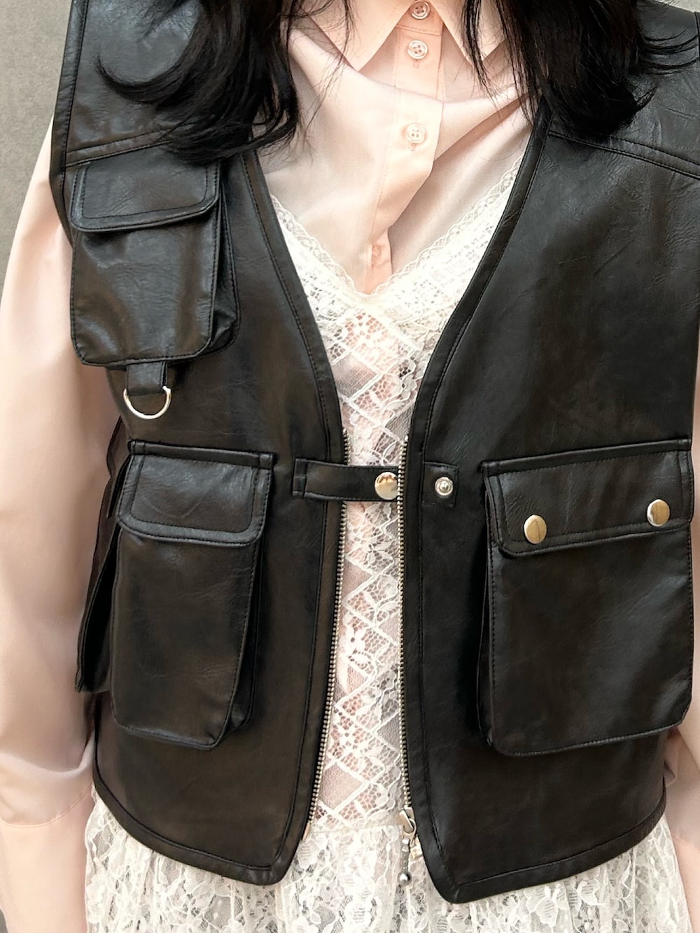 ブラック系のパンプス、ホワイト系のワンピース、ブラック系のベストを着用したレディースの冬コーディネートの5枚目の写真