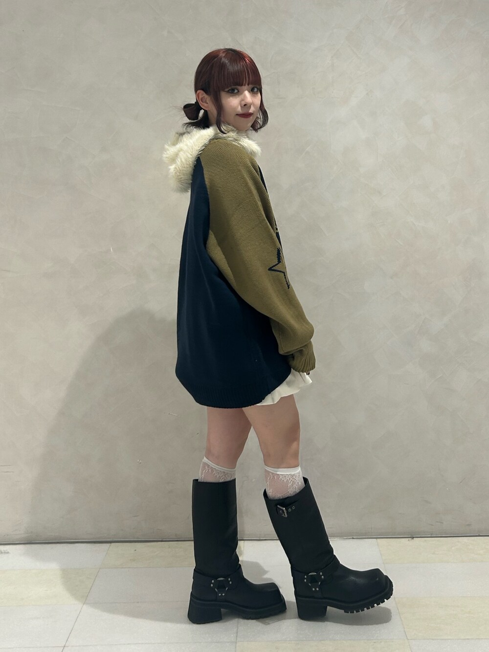 ブラック系のブーツ、ホワイト系のスカート、ブルー系のニット/セーターを着用したレディースの秋コーディネートの4枚目の写真