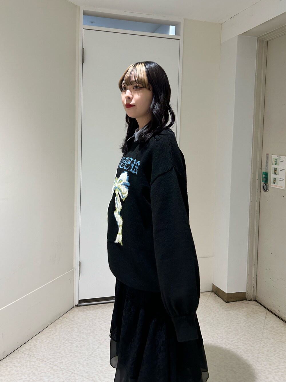 ブラック系のニット/セーター、ブラック系のスカート、ブラック系のブーツを着用したレディースの冬コーディネートの4枚目の写真