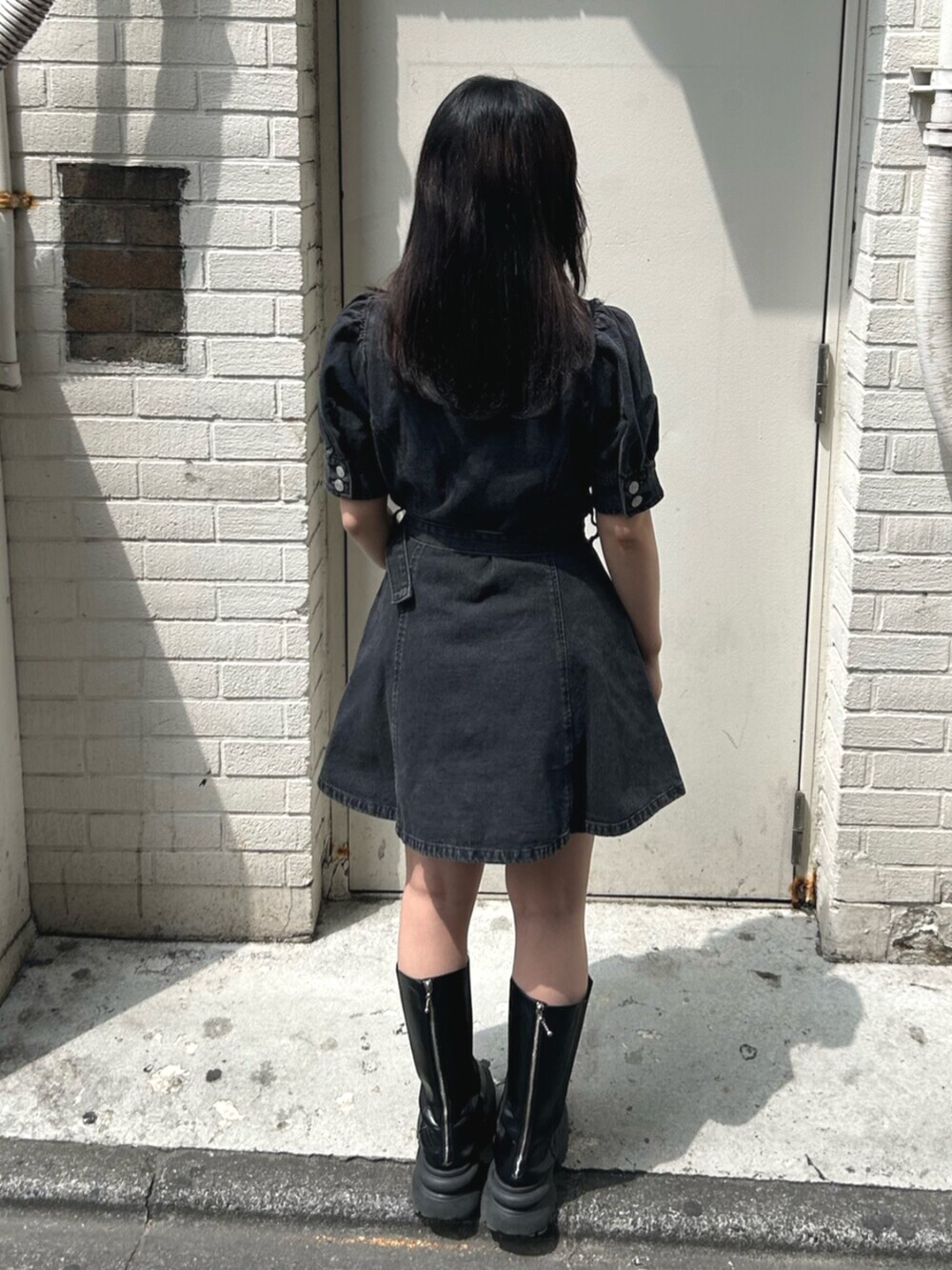 ブラック系のブーツ、ブラック系のワンピース、ホワイト系のチョーカーを着用したレディースの春コーディネートの3枚目の写真