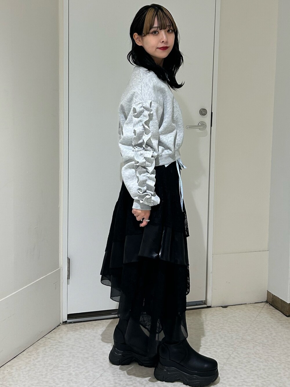 ブラック系のスカート、グレー系のスウェット、ブルー系のシャツ/ブラウスを着用したレディースの冬コーディネートの2枚目の写真