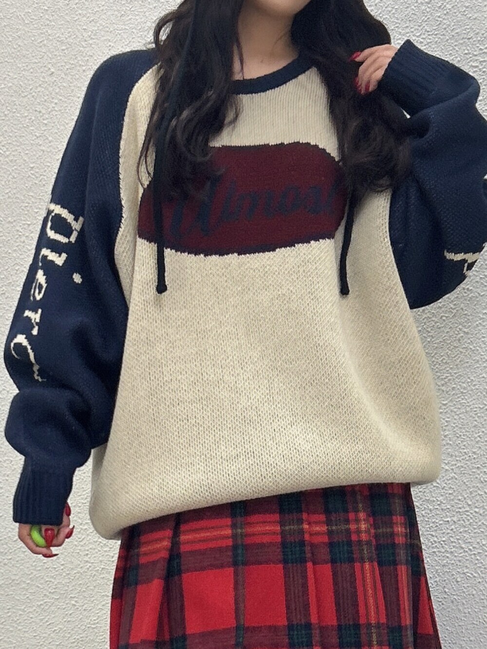 ブラック系のブーツ、ホワイト系のニット/セーター、レッド系のスカートを着用したレディースの秋コーディネートの4枚目の写真