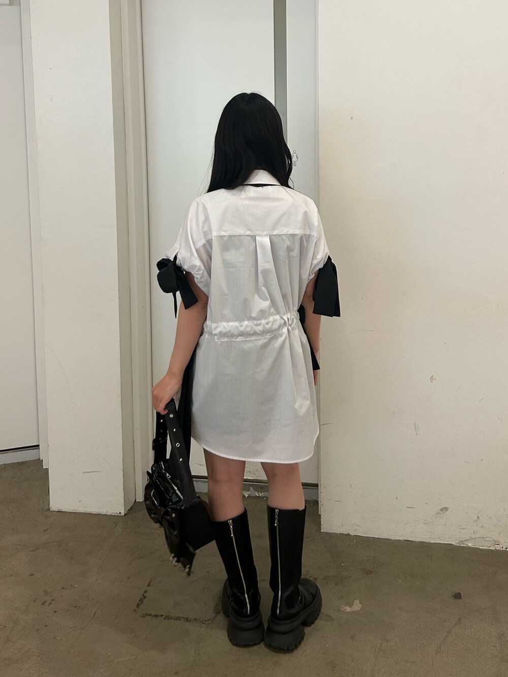 ホワイト系のシャツ/ブラウス、ブラック系のネクタイ、ブラック系のブーツを着用したレディースの春コーディネートの3枚目の写真