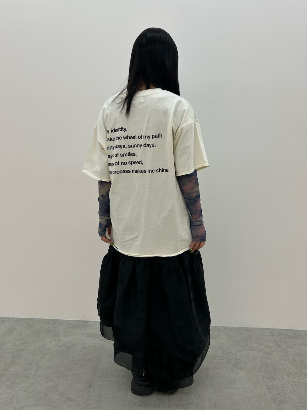 ホワイト系のTシャツ/カットソー、ブラック系のスカート、ブラック系のブーツを着用したレディースの春コーディネートの3枚目の写真