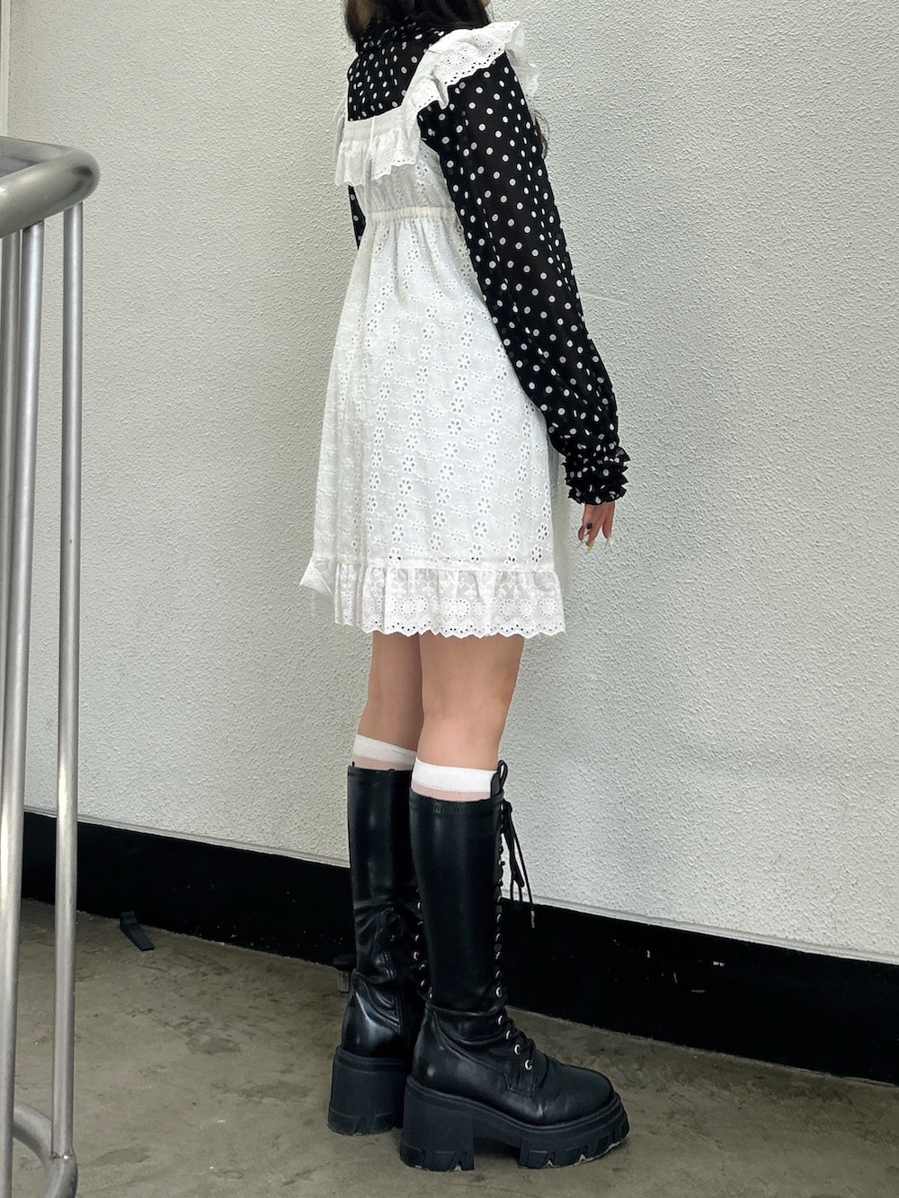 ブラック系のシャツ/ブラウス、ホワイト系のワンピース、ブラック系のブーツを着用したレディースの春コーディネートの2枚目の写真
