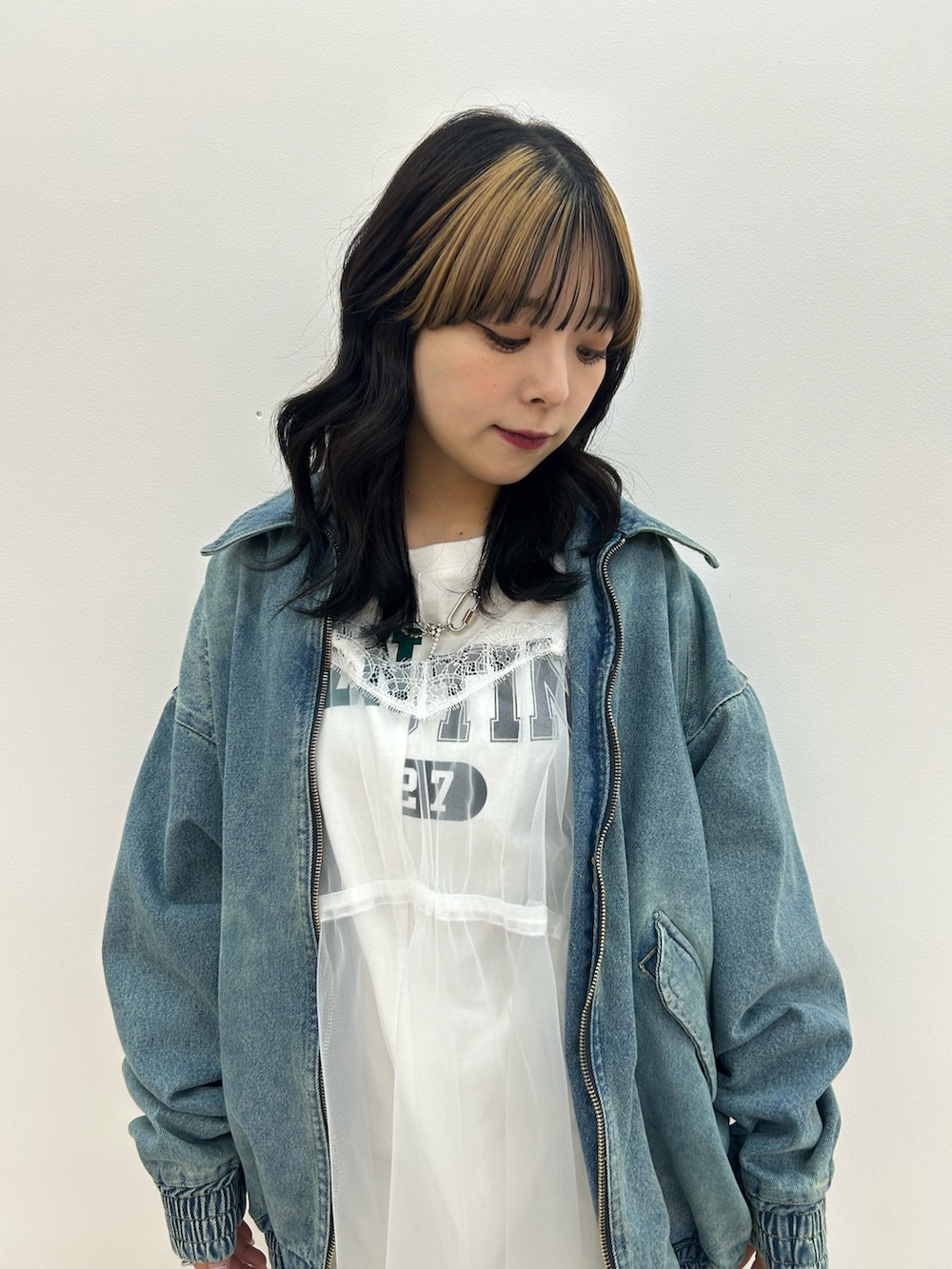 ブルー系のデニムジャケット、ホワイト系のワンピース、ブラウン系のブーツを着用したレディースの冬コーディネートの5枚目の写真
