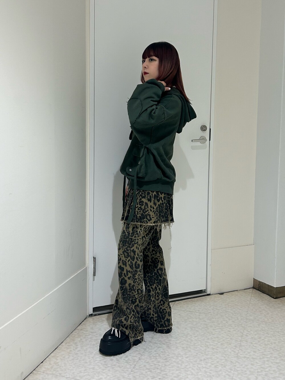 ブラウン系のその他パンツ、ブラック系のドレスシューズ、グリーン系のパーカーを着用したレディースの秋コーディネートの2枚目の写真