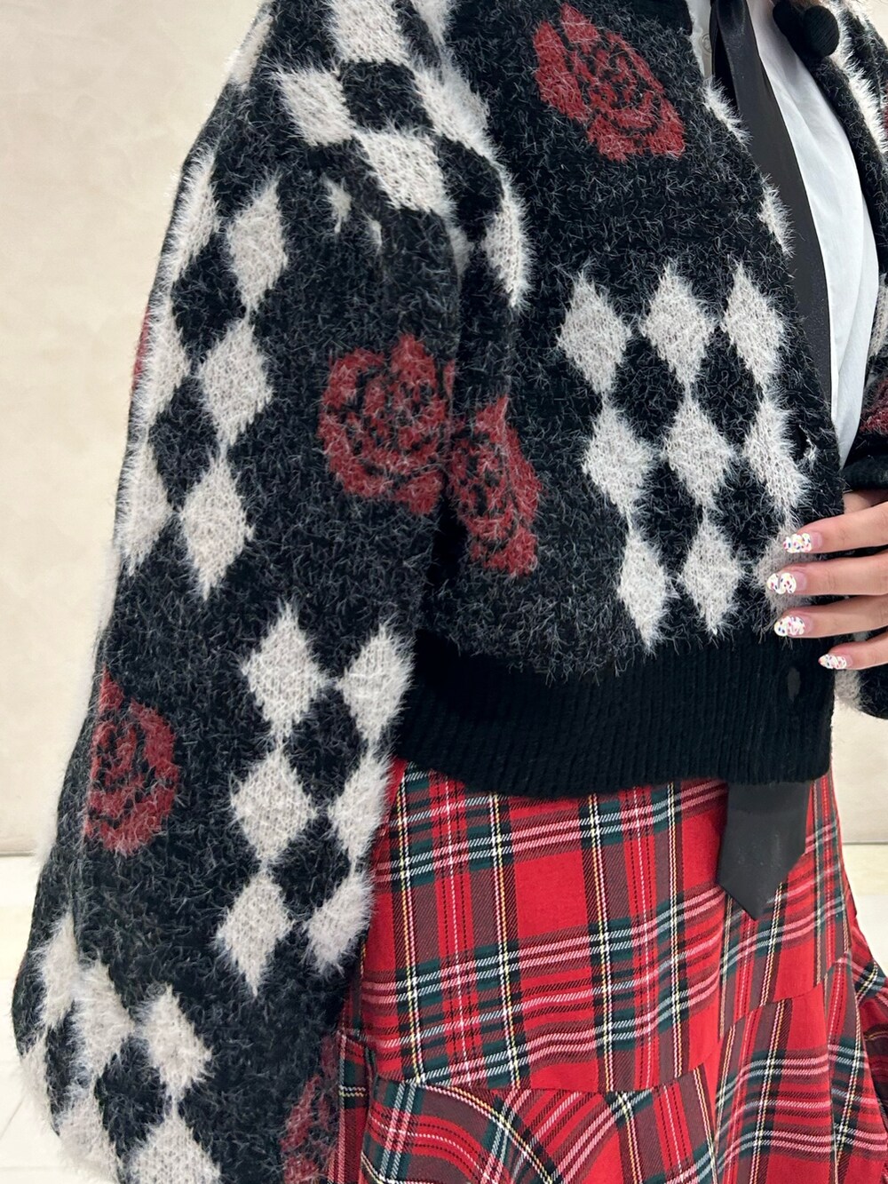 レッド系のスカート、ブラック系のドレスシューズ、ブラック系のカーディガン/ボレロを着用したレディースの秋コーディネートの5枚目の写真