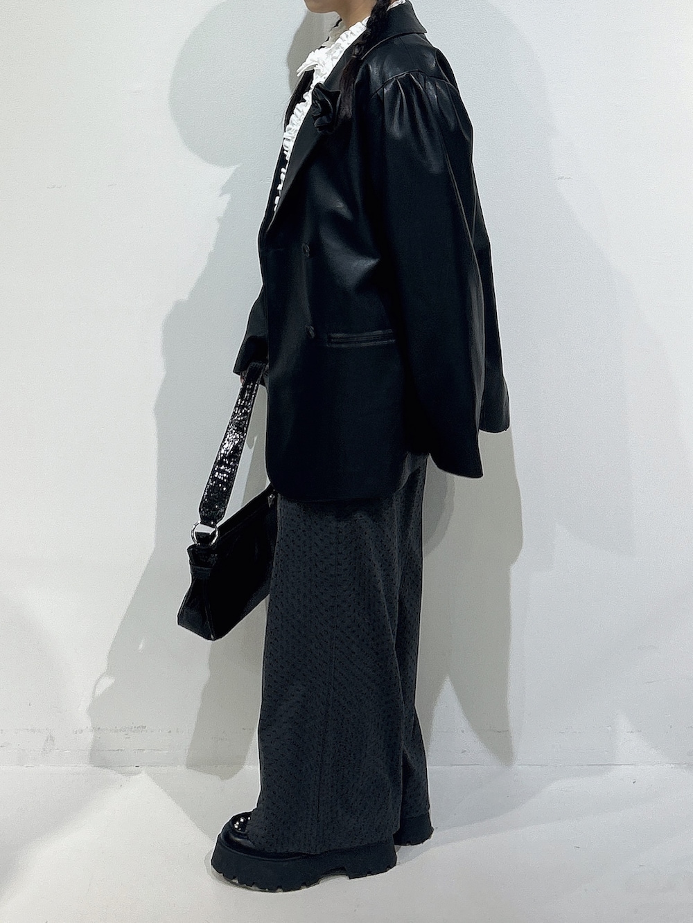 ホワイト系のシャツ/ブラウス、ブラック系のテーラードジャケット、グレー系のスウェットパンツを着用したレディースの冬コーディネートの2枚目の写真