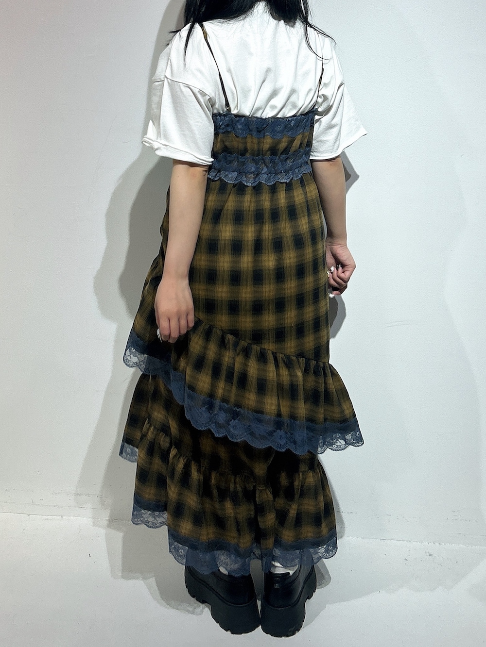イエロー系のワンピース、ホワイト系のTシャツ/カットソー、ブラック系のローファーを着用したレディースの春コーディネートの3枚目の写真
